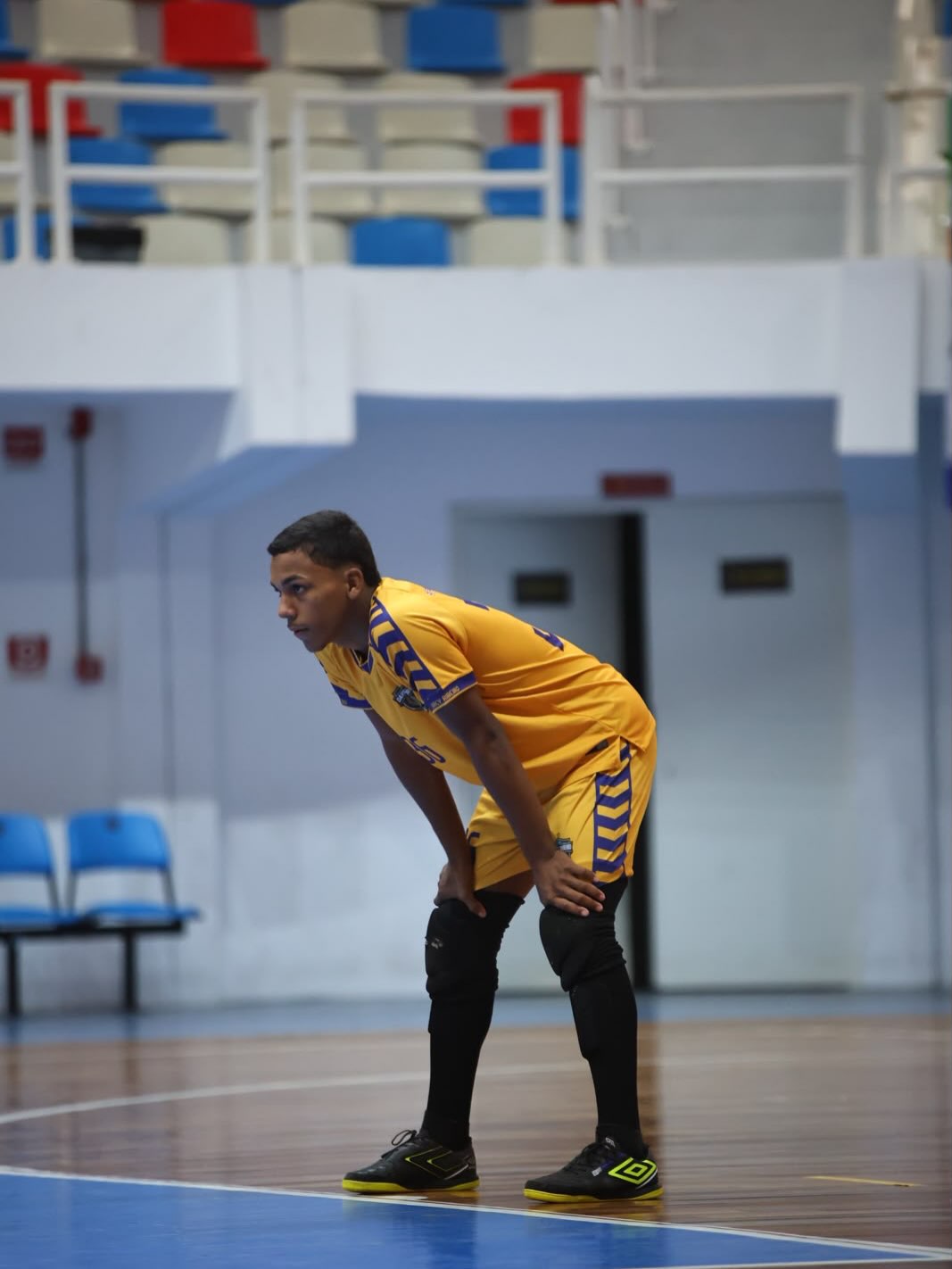 Jogador de futsal concentrado em quadra durante a partida